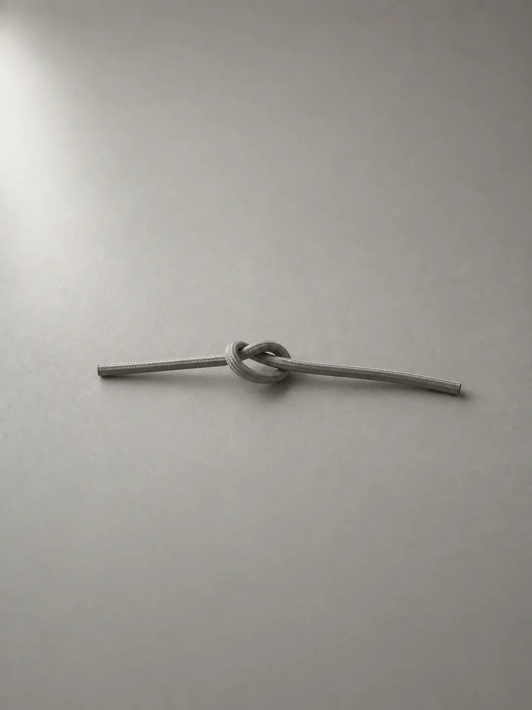 A thin cable knotted once on a desk