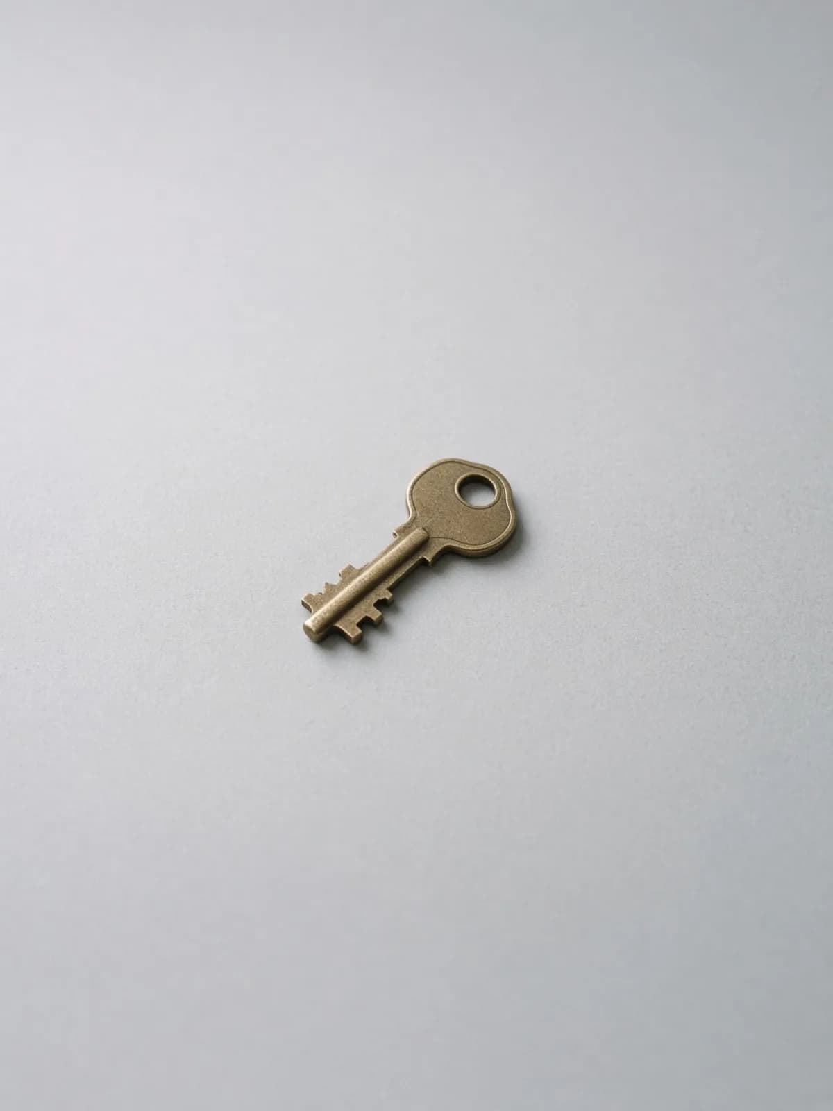 A single brass key lying flat on a desk